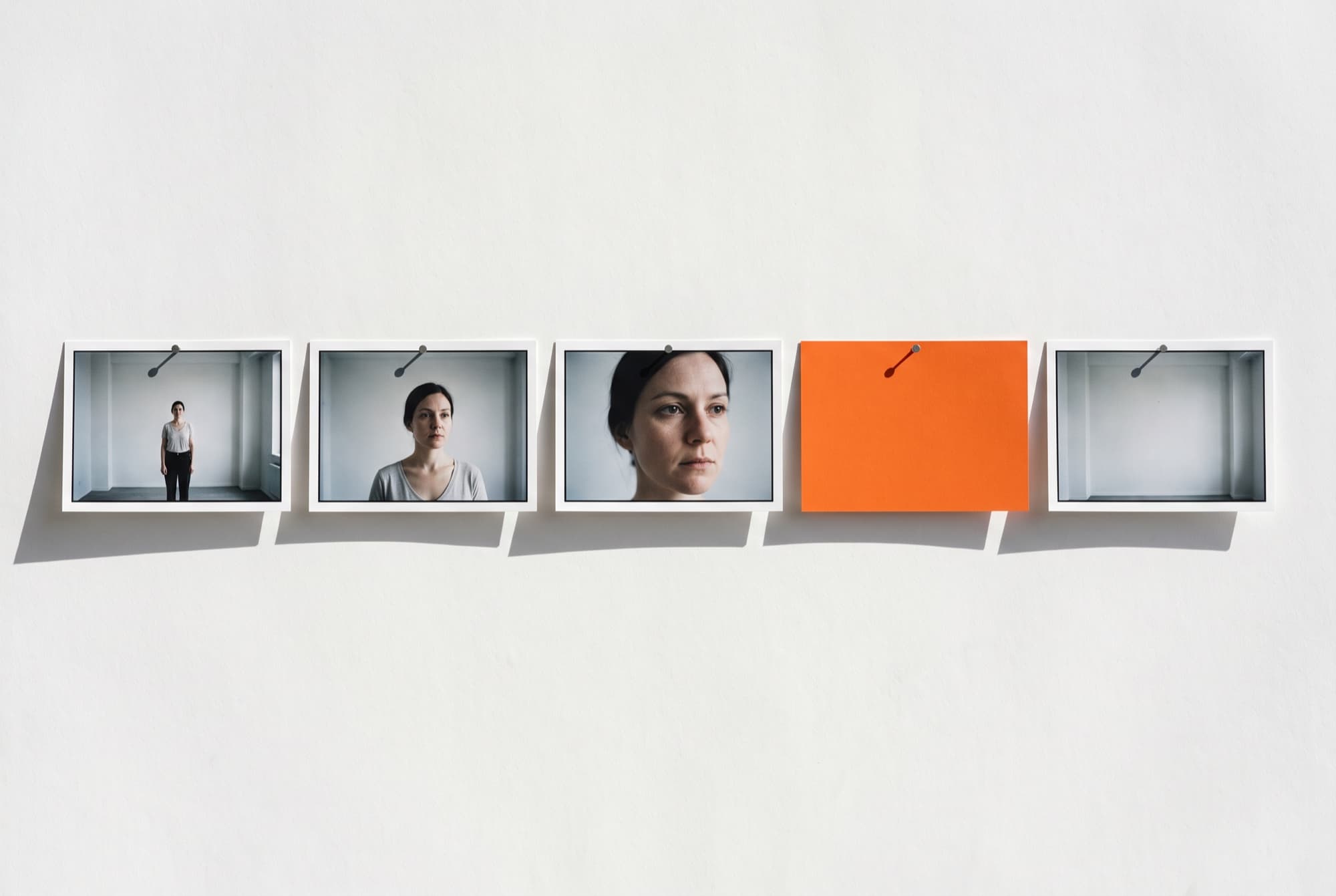 Five printed shot frames pinned in a row on paper, a blank orange rectangle pinned between them
